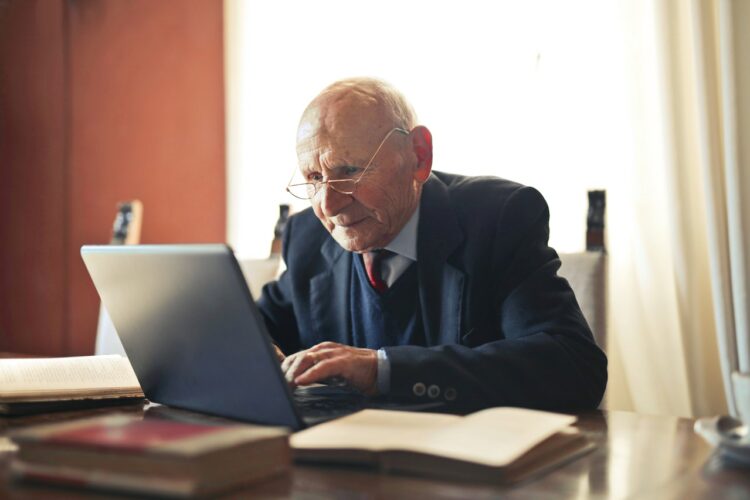 Oudere man achter laptop