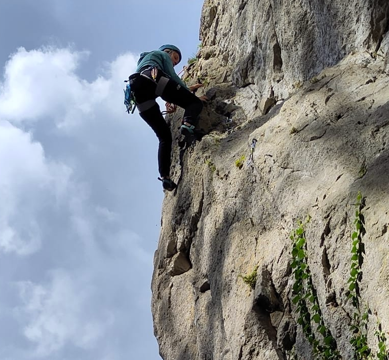 Janita hangend aan een rots in Dinant gezien vanaf de grond